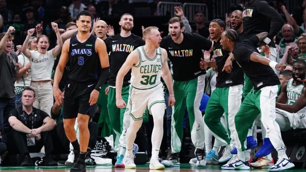 Sam Hauser celebrates in front of the Celtics bench after a three-point basket.